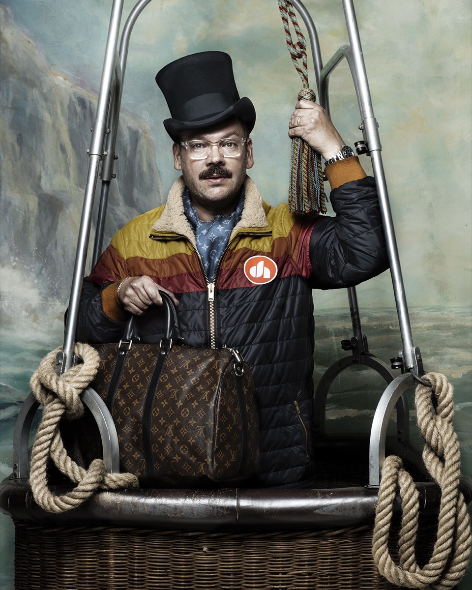 Derek in a top hat, standing in a theatrical balloon basket